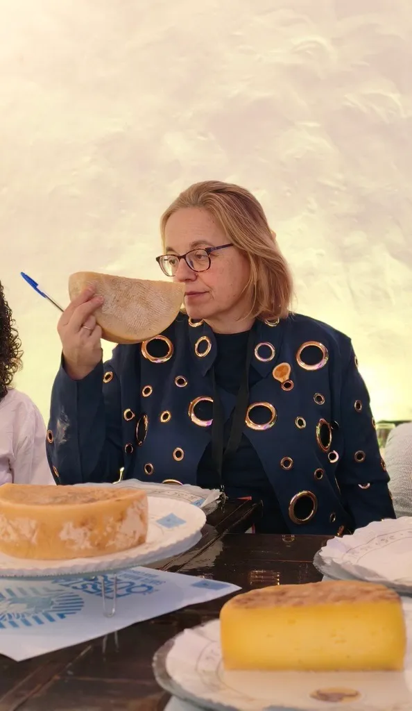 Ruth Lozano huele una cuña de queso, con la mirada baja y concentrada, durante la fase olfativa de una cata de concurso.